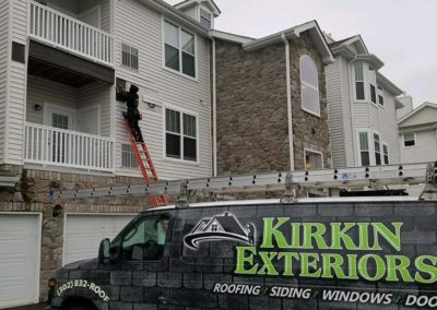 Kirkin Exteriors worker working on siding for a residential home